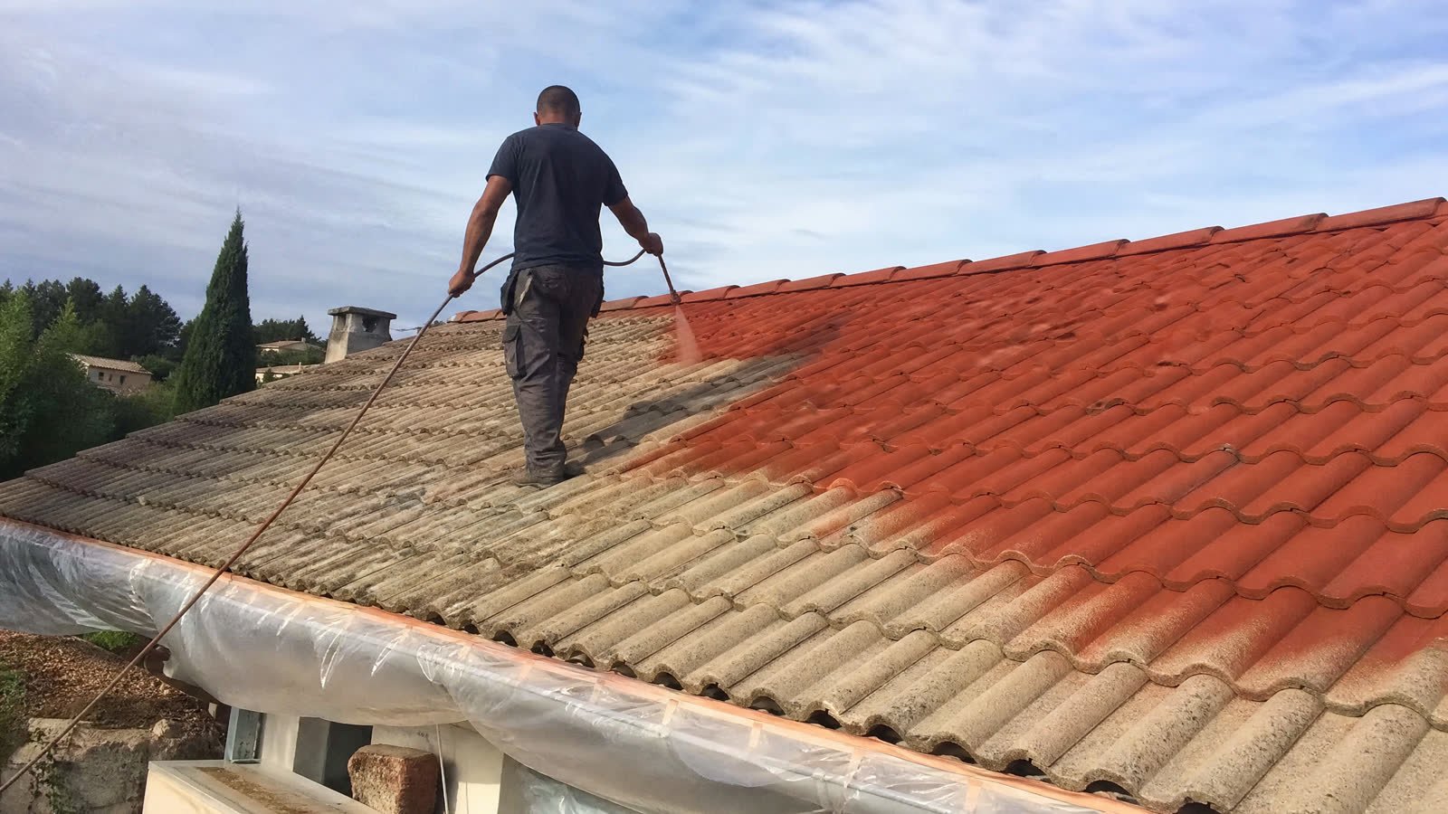 Application d'un traitement coloré sur une toiture en tuiles béton dans le Gard