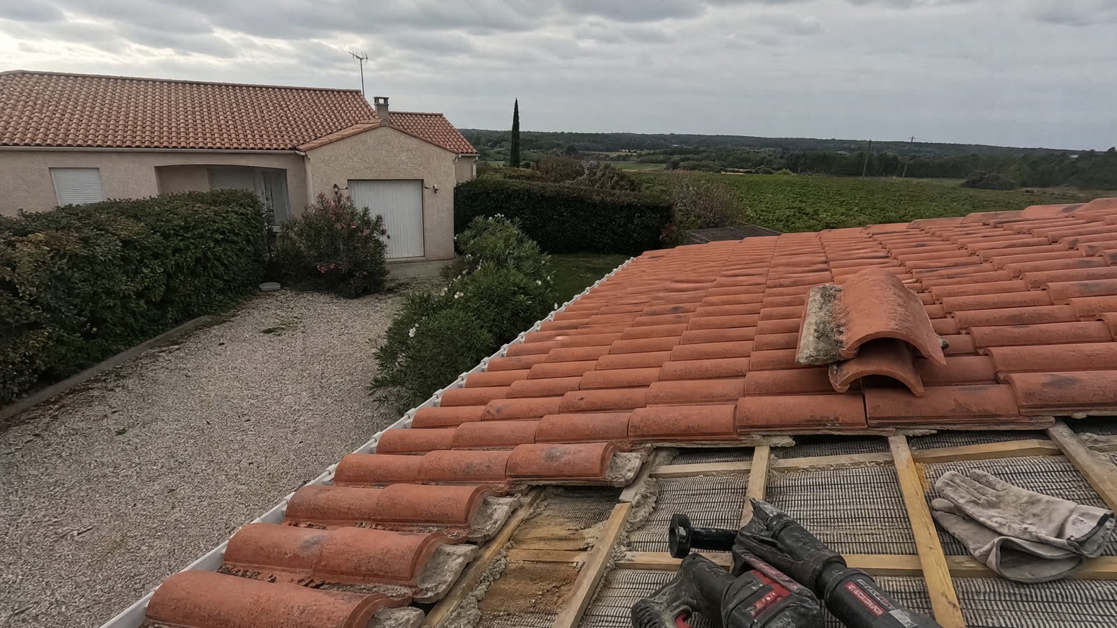 Application d'un hydrofuge coloré sur une toiture en tuiles — détail du chantier