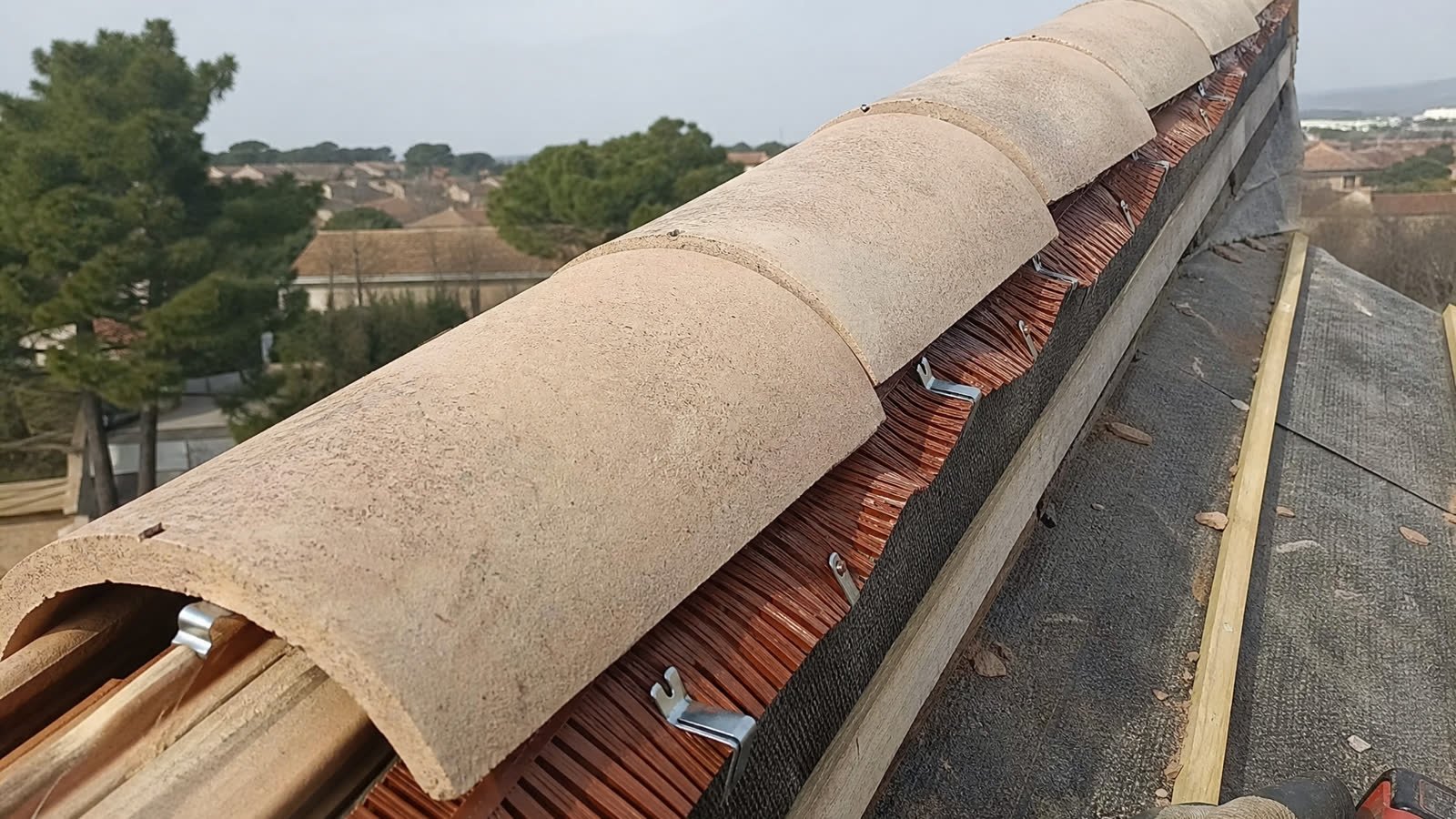 Pose de tuiles canal en terre cuite sur une construction neuve — détail du chantier
