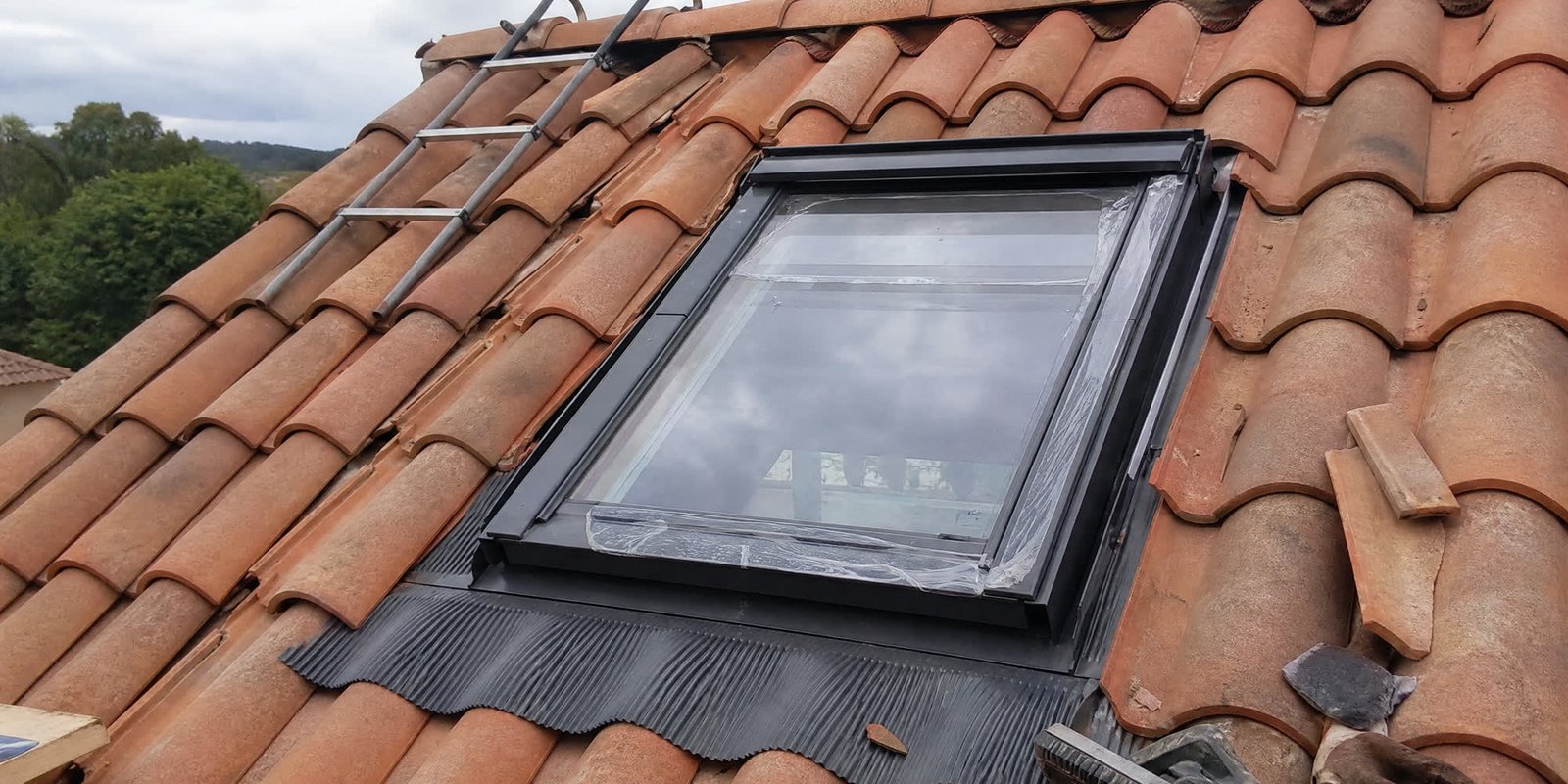 Fenêtre de toit posée sur une toiture en tuiles